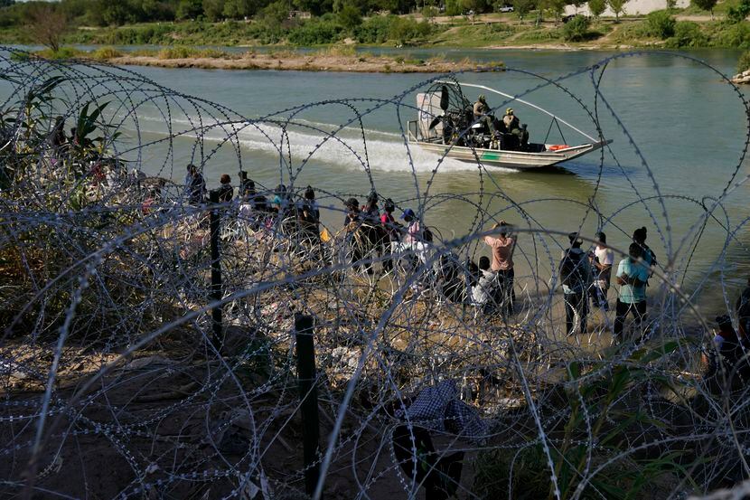 Migrantes que cruzaron a Estados Unidos desde México se encuentran con alambre de púas en la...