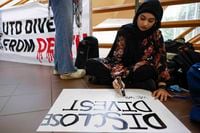 UTD sophomore Sumehra Hassan makes a sign during a pro-Palestine sit-in along the hallway of...