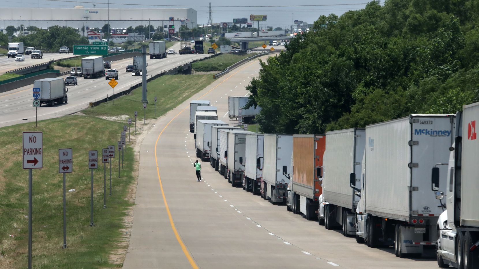 A long line of delivery trucks waits to enter the Amazon Fulfillment Center in South Dallas...