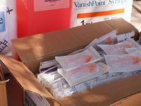 Una caja con jeringas para una clínica móvil de vacunación contra la gripe en Grand Prairie...