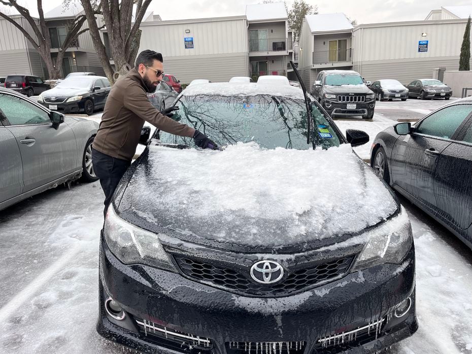 Víctor Jasson removes the ice from his car to drive to his shift at FedEx on Wednesday,...