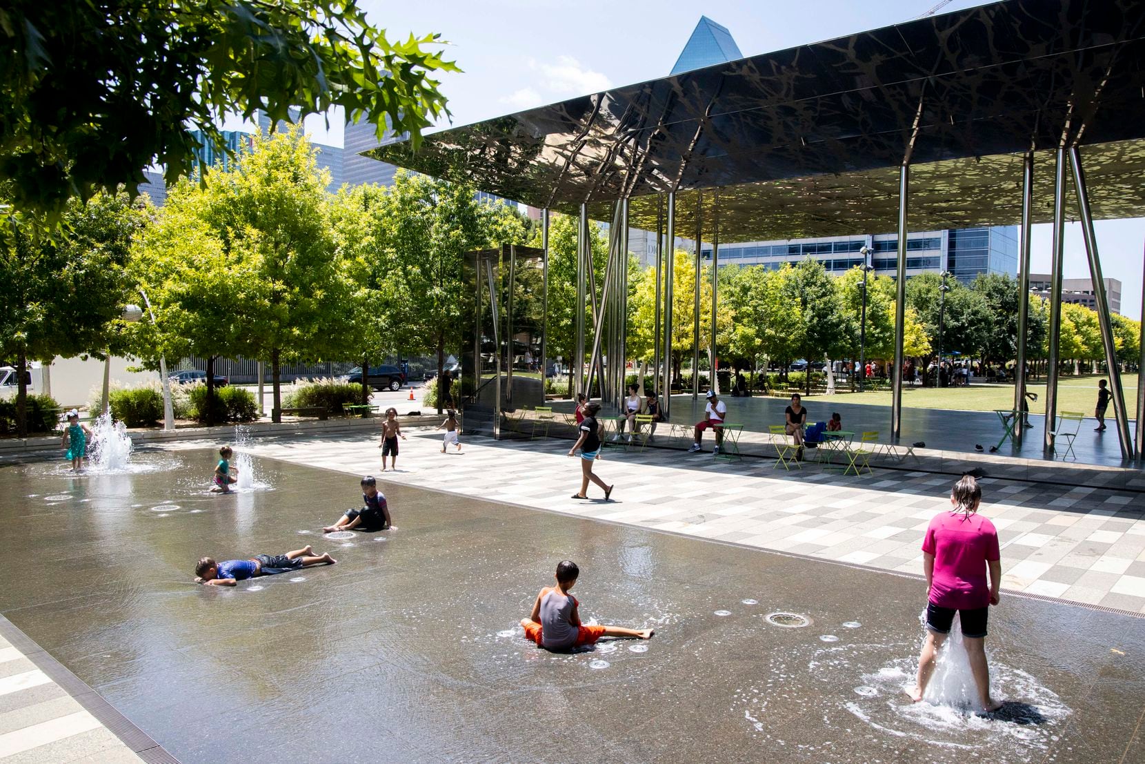 Kids cooled down in a water park at Klyde Warren Park on Tuesday. In Dallas-Fort Worth, an...
