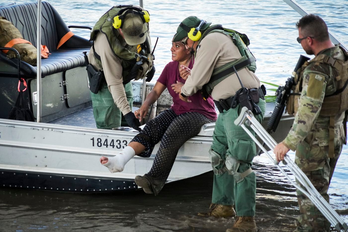 Maria, a Venezuelan migrant who was on crutches, is assisted from a boat by U. S. Border...