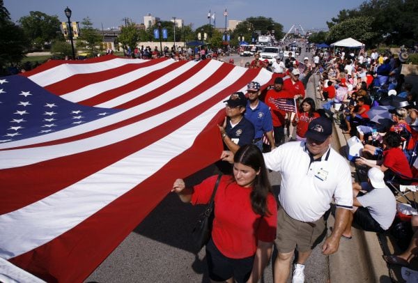 Men and women carry a large American flag during the annual Fourth of July Parade in...