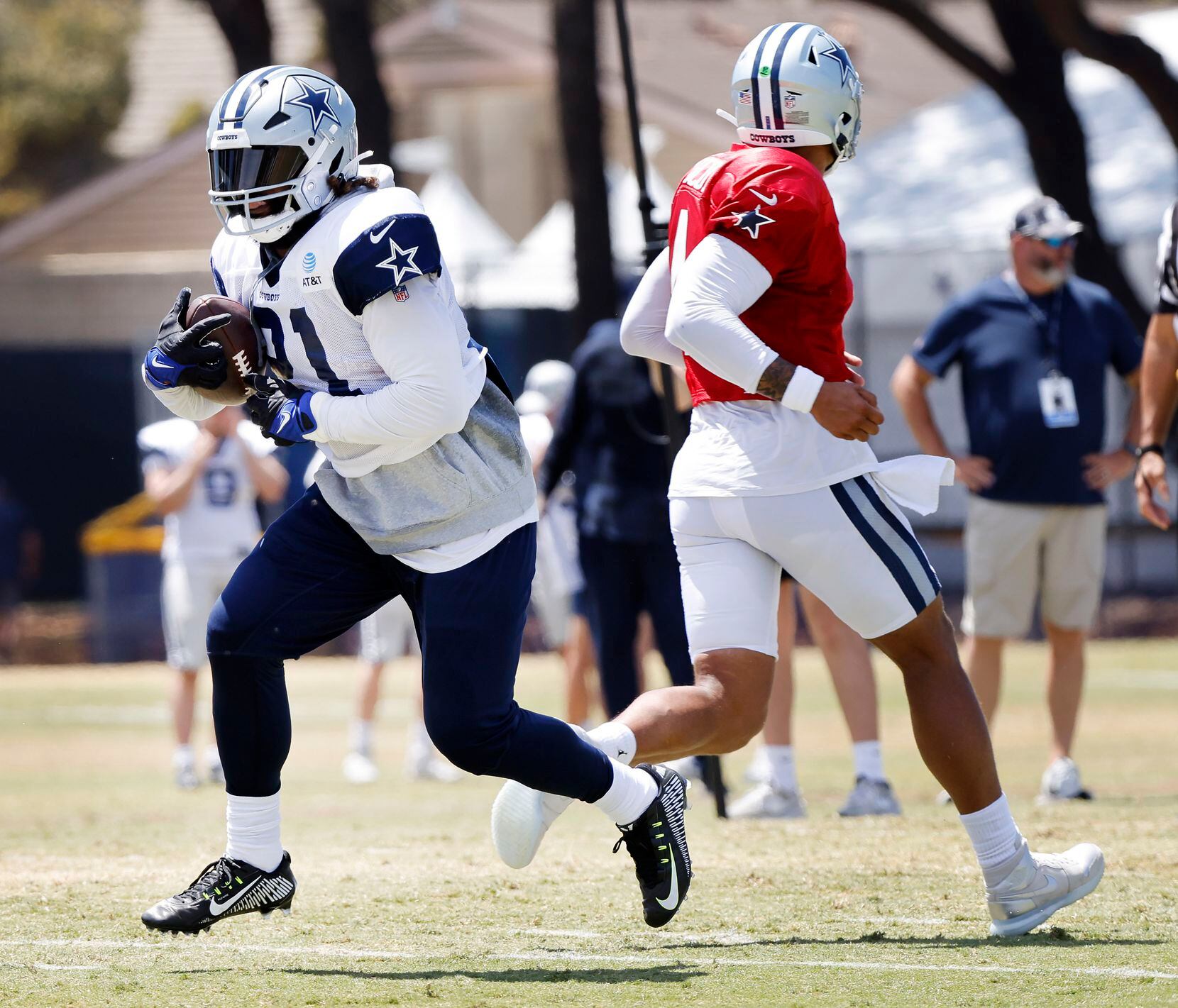 Dallas Cowboys running back Ezekiel Elliott (21) takes the handoff from quarterback Dak...