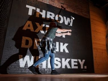 Elisa Grace, a staffer at Whiskey Hatchet, demonstrates her two-handed throwing technique at the new bar in Deep Ellum.