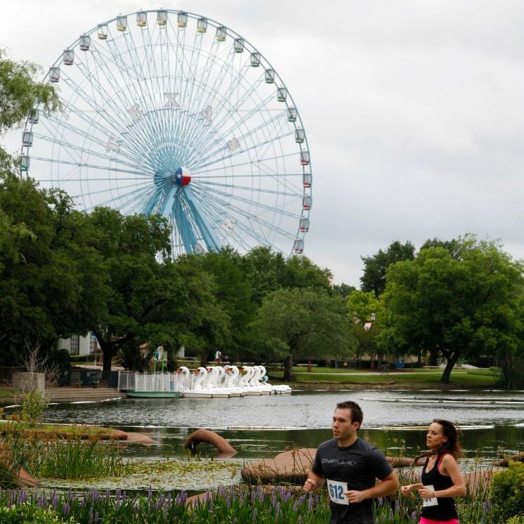 Runners pass the Leonhardt Lagoon and Texas Star at Fair Park.