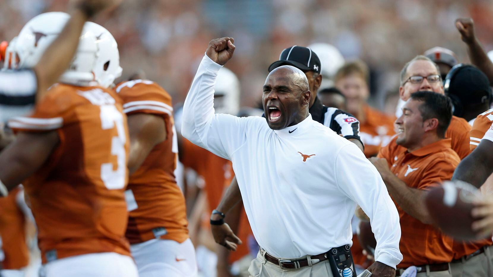 Texas Longhorns head coach Charlie Strong celebrates after the first interception of the...