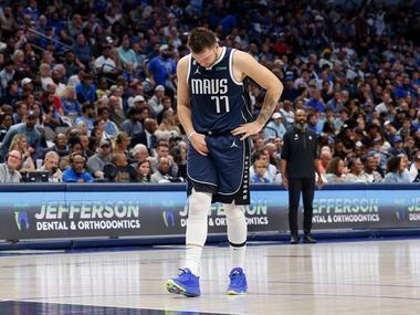 Dallas Mavericks guard Luka Doncic (77) grabs his groin after slipping on the court during...