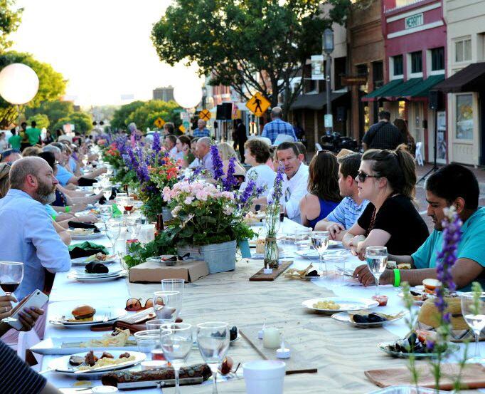 Guests eat and drink at an outdoor table during Night Out on 15th Street in downtown Plano. 