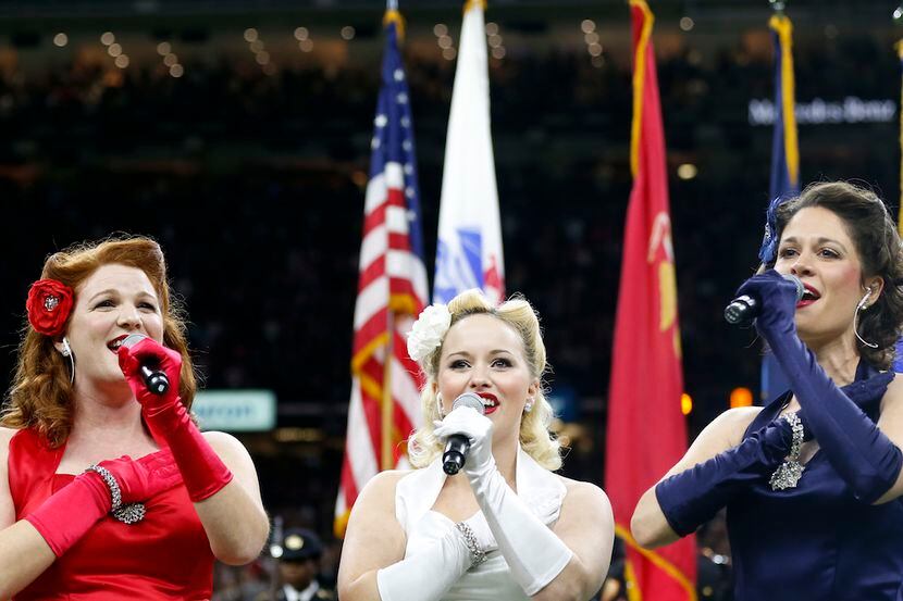 The Victory Belles sing the National Anthem before an NFL football game.