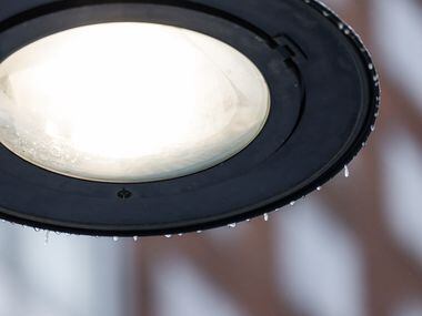 A street lamp with frozen rain as sleet covered downtown Dallas on Tuesday, Jan. 31, 2023....