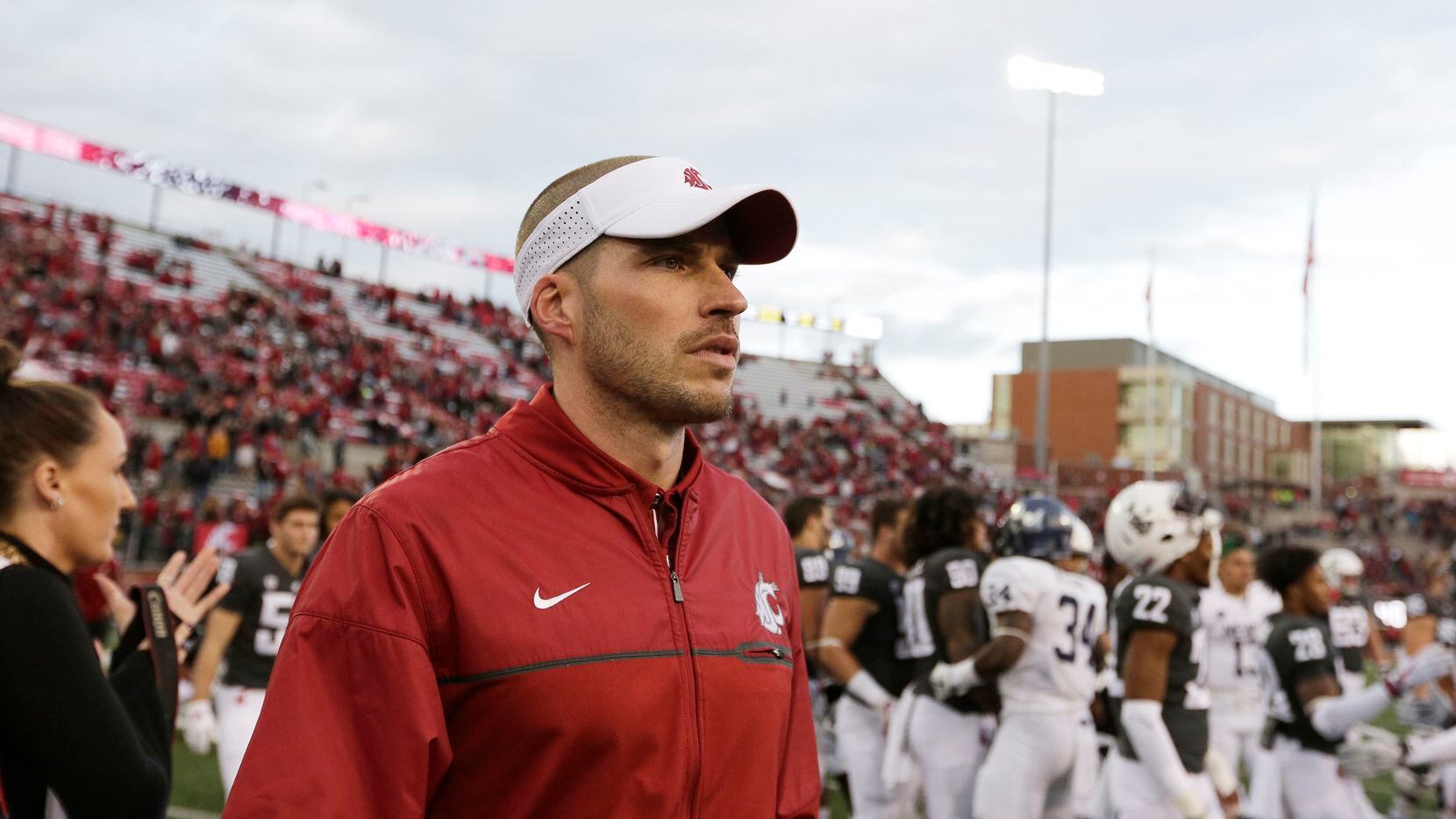 FILE - Alex Grinch, then the defensive coordinator at Washington State, walks onto the field...
