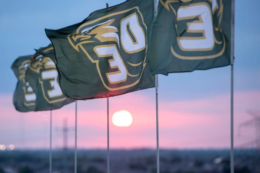 DeSoto flags fly as the sun sets before the start of a high school football game against...