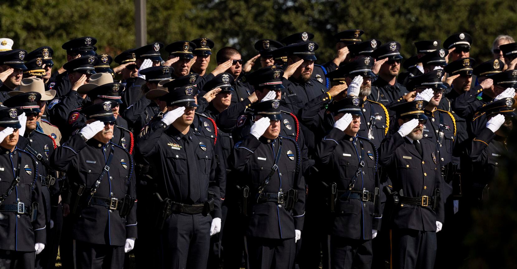 Officers salute during the funeral service for Carrollton police Officer Steve Nothem on...