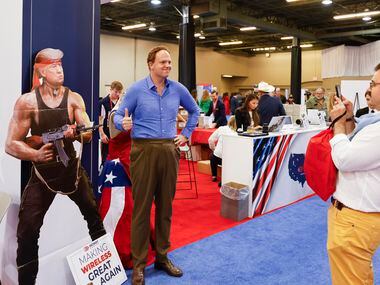 Attendees take a photo with a cardboard cutout of former President Donal Trump during the...