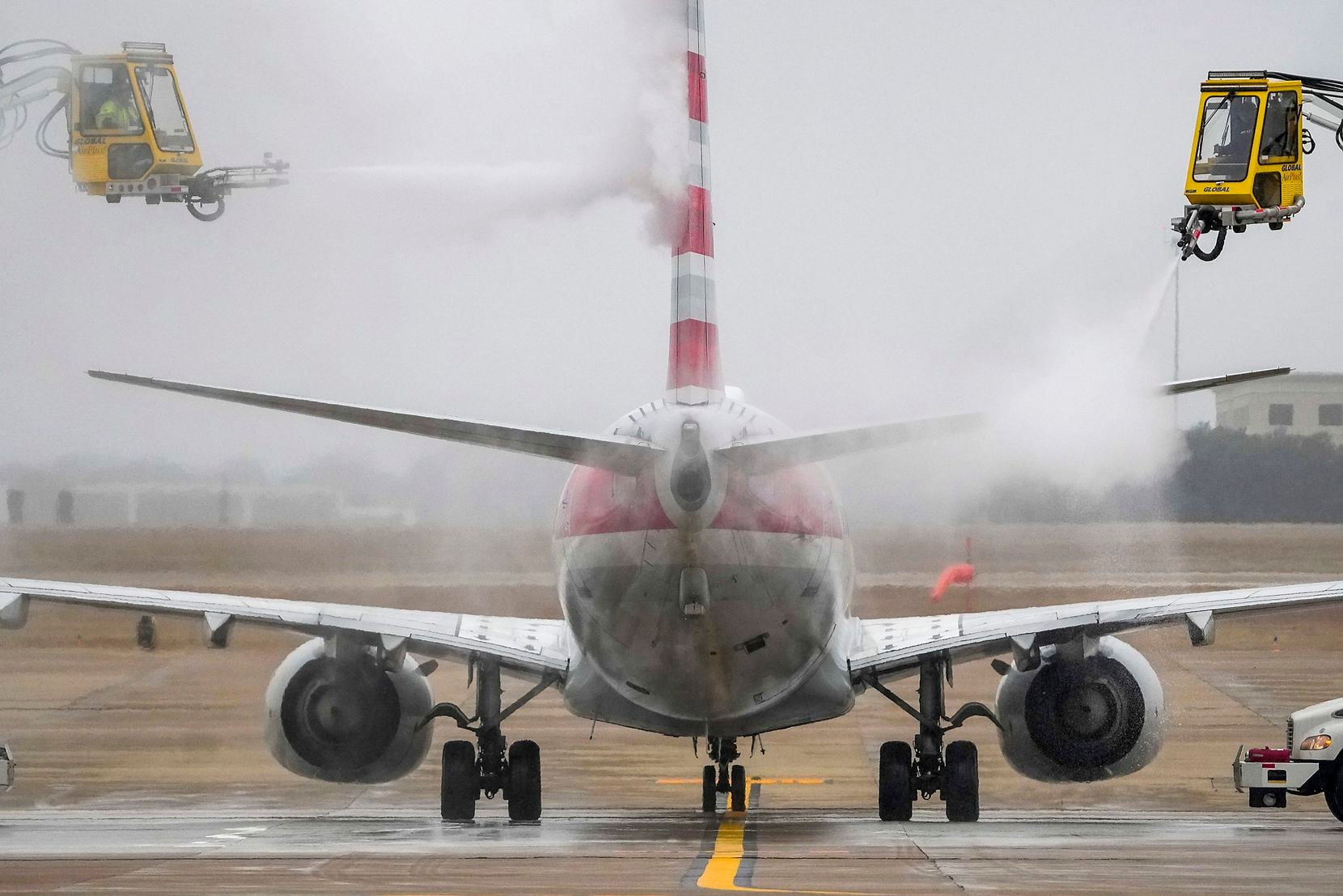 An American Airlines aircraft undergoes deicing procetures on Monday, Jan. 30, 2023, at DFW...