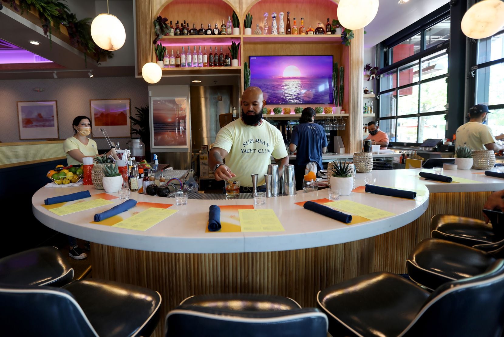 Guests can sit in a variety of cabins inside, outside, or (pictured) at the bar at the Suburban Yacht Club in Plano.