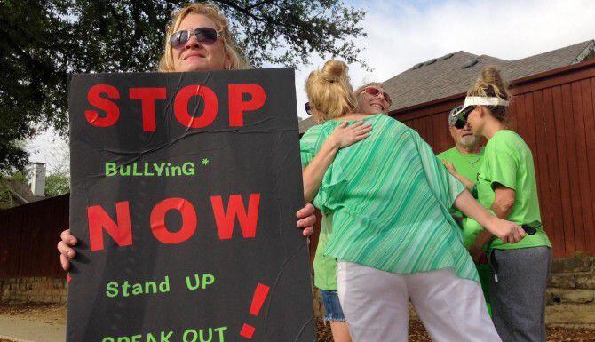 Tami Turner, (izq.) sostiene una pancarta durante la protesta contra el bullying que...