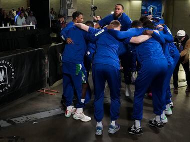 Dallas Mavericks players huddle around center JaVale McGee (00) before the take the court...