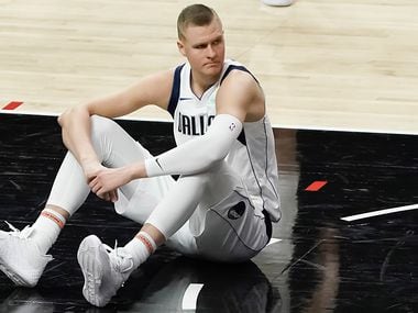 Dallas Mavericks center Kristaps Porzingis sits on the court after a foul during the second half of an NBA playoff basketball game against the LA Clippers at Staples Center on Saturday, May 22, 2021, in Los Angeles.