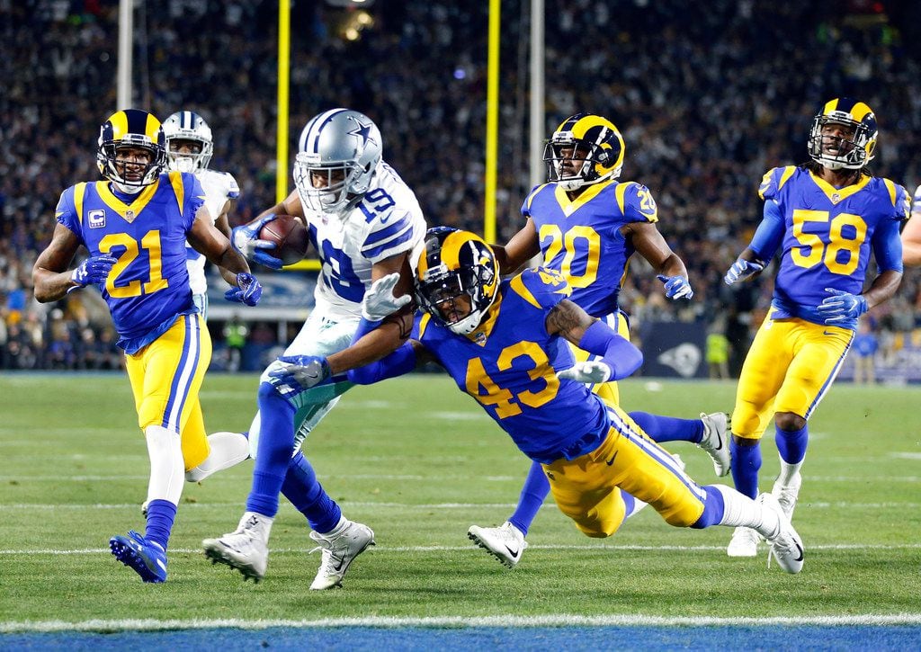 FILE - Cowboys receiver Amari Cooper (19) scores a touchdown as he bounces off Rams safety...