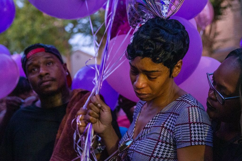 Sontravia Elder (center) and her immediate family attend a vigil honoring the life of her 9-year-old daughter, Brandoniya Bennett, at the Roseland Townhomes.