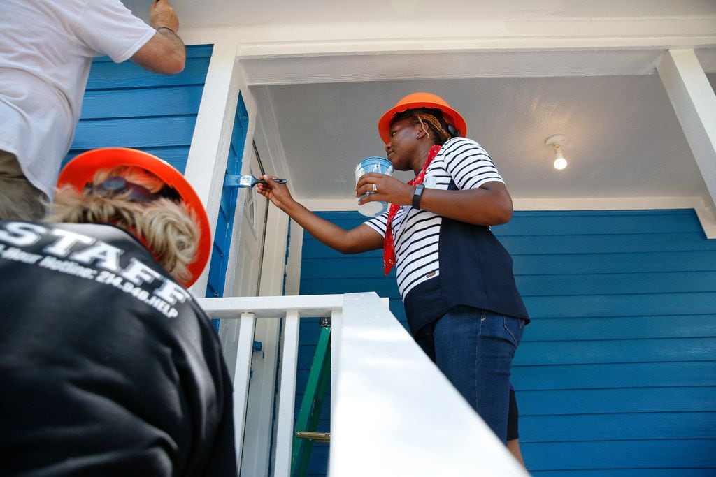 Chikwanda Chisanga, a volunteer from Child Protective Services, paints a home in West Dallas as part of the Dallas Area Habitat for Humanity on June 1, 2018. 