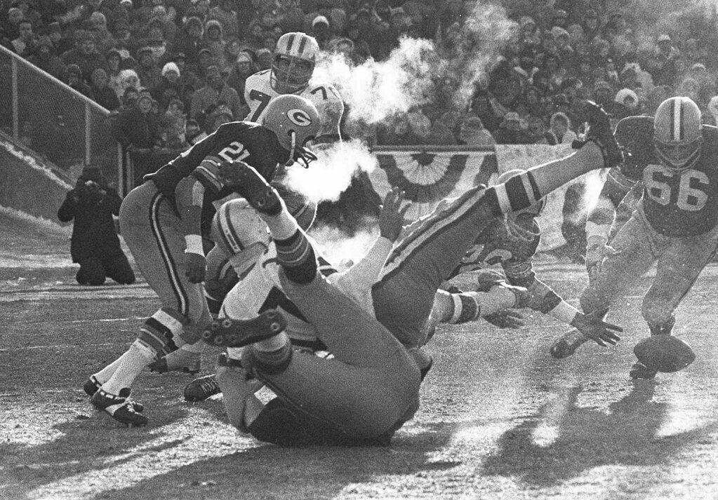 In this Dec. 31, 1967 file photo, Dallas Cowboys quarterback Don Meredith (17) falls backwards onto a Green Bay Packers player as he fumbles tha ball in the third quarter of the National Football League Championship game known as the Ice Bowl at Lambeau Field in Green Bay, Wisc. Packers' Herb Adderly (26), partially obscured behind Meredith's legs, recovered the fumble. In the history of NFL games, none stands out for the brutal conditions in which it was played like the NFC championship on the last day of 1967. Simply dubbed the Ice Bowl, those who participated in Cowboys-Packers that day at Lambeau Field still shiver when talking about it.