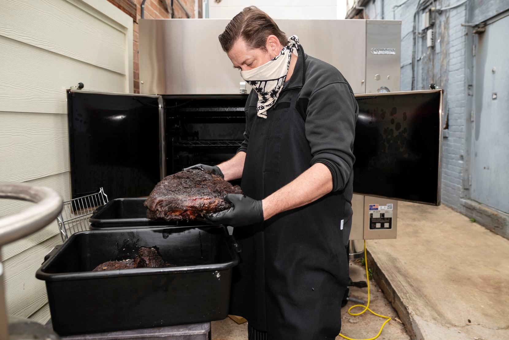 Owner Andrew Kelley, of New York Sub, holds a smoked brisket he prepared overnight at his...
