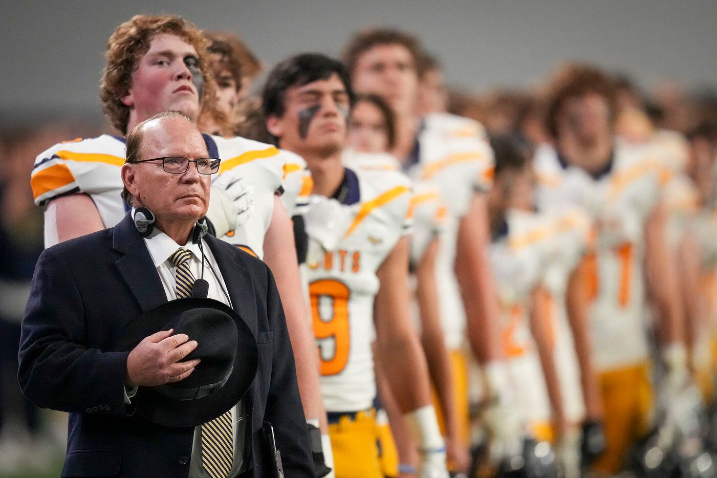 Highland Park head coach Randy Allen stands with his players for the national anthem before...