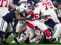 New York Giants running back Saquon Barkley (26) is dropped for a loss by Dallas Cowboys...