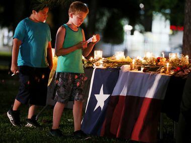Children carry candles following a vigil along Avenue M and Highway 6 following a shooting...