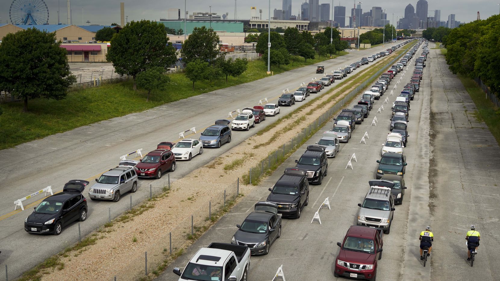 Cars lined up for distributions from the North Texas Food Bank at Fair Park on May 14. About...
