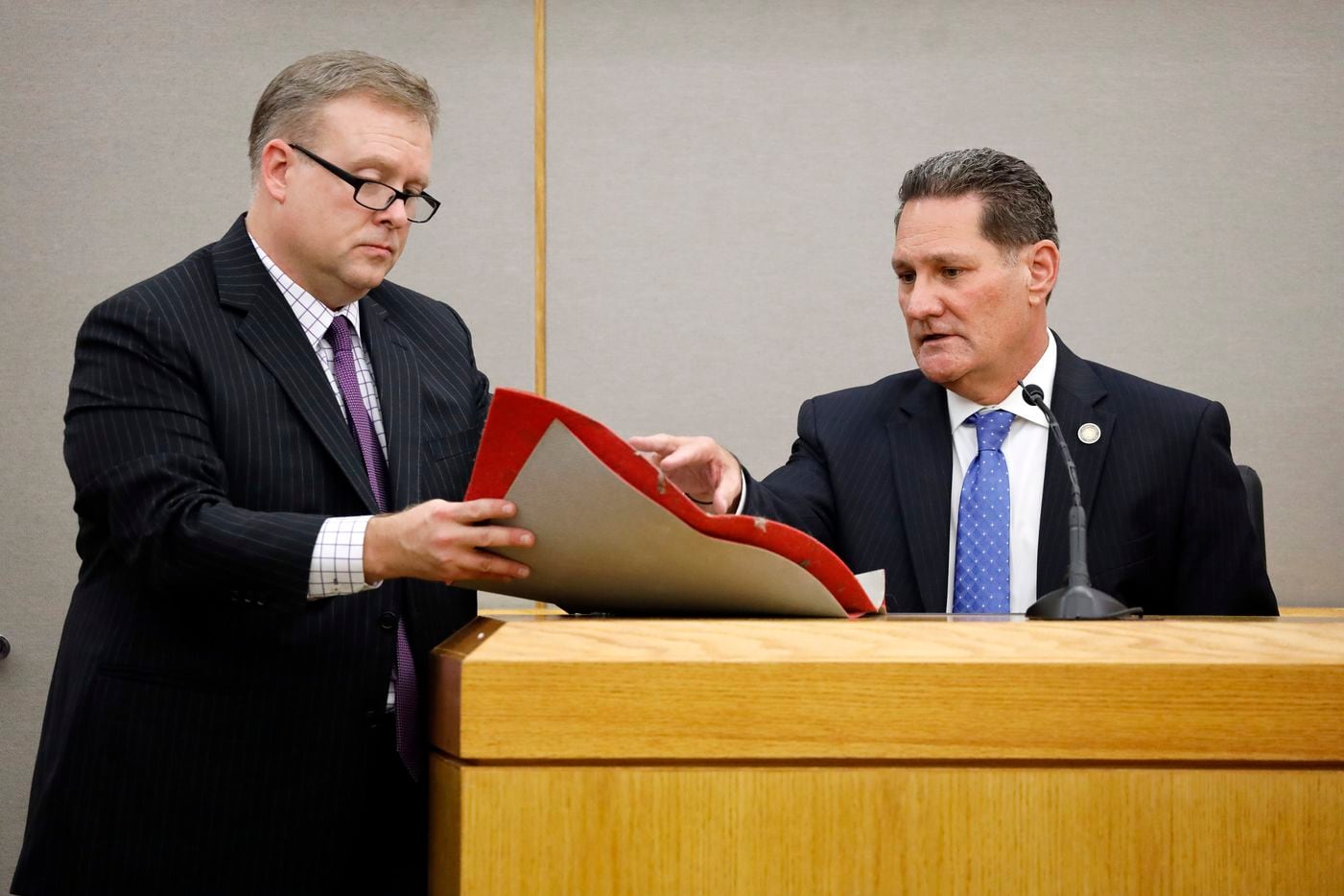 Dallas County District Attorney criminal investigator Michael Grice (right) shows Assistant District Attorney Jason Hermus (left) Botham Jean's front door mat he acquired through a court order. 
