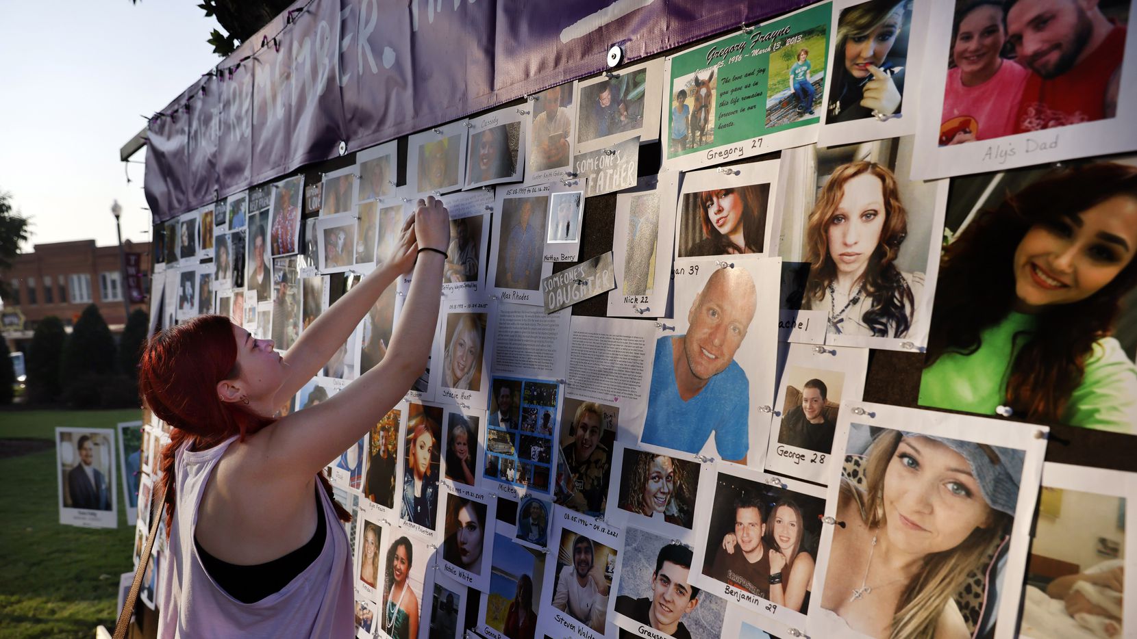 Isabella Neel escribe un mensaje en un mural con fotos para recordar a las víctimas de...