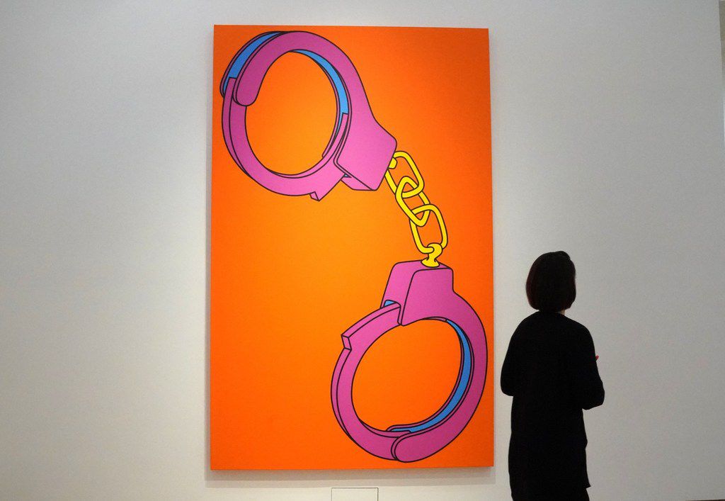 A woman walks past the work of artist Michael Craig-Martin titled Handcuffs at Christie's New York during a press preview on Feb. 8, 2019 — Christies presents The George Michael Collection: a opportunity for collectors, art lovers and fans to acquire works from the legendary recording artists private collection. Over 200 lots will be offered across a live auction in London on 14 March and an online sale from 815 March.