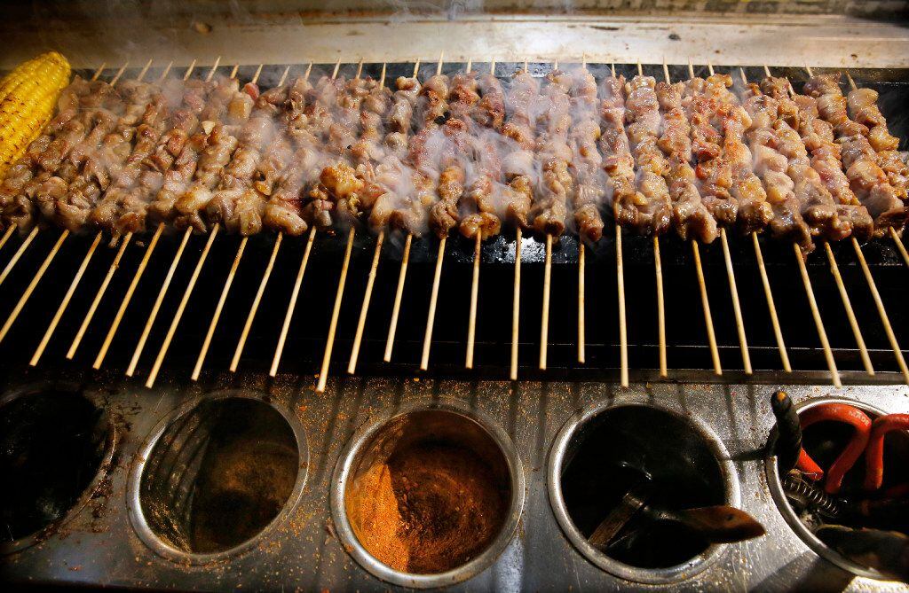 Lamb skewers of lamb are grilled over a pit of coals at FatNi. (Tom Fox/Staff Photographer)