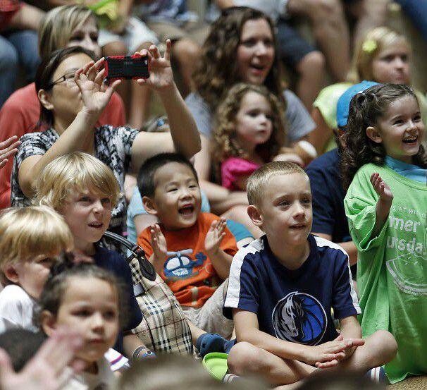 Children in the audience laugh at circus performers who are promoting upcoming circus shows...