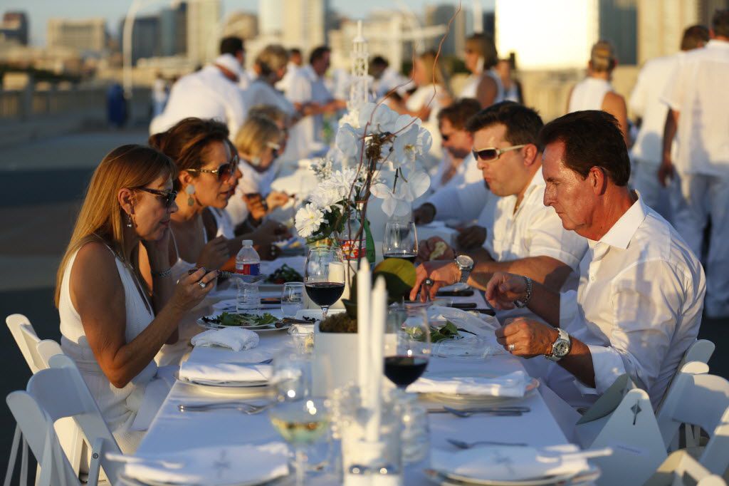 Guests dine during the inaugural Diner en Blanc Dallas on the Continental Avenue Bridge in...