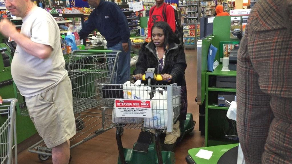 Mythia Joseph navigates the checkout area on a motorized scooter at the Wal-Mart near Hall...