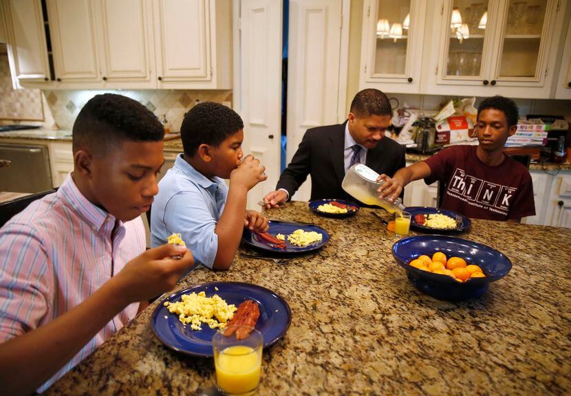 From left, William Waters, Christopher Waters and Joshua Waters eat breakfast with their...