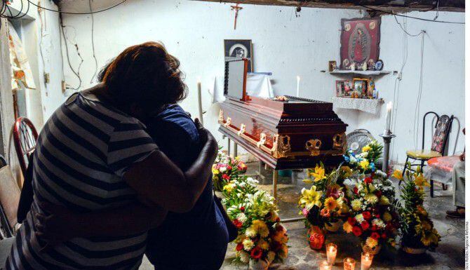 Familiares lloran frenten al féretro de Miguel Ángel Jiménez, un activista que ayudó en la...