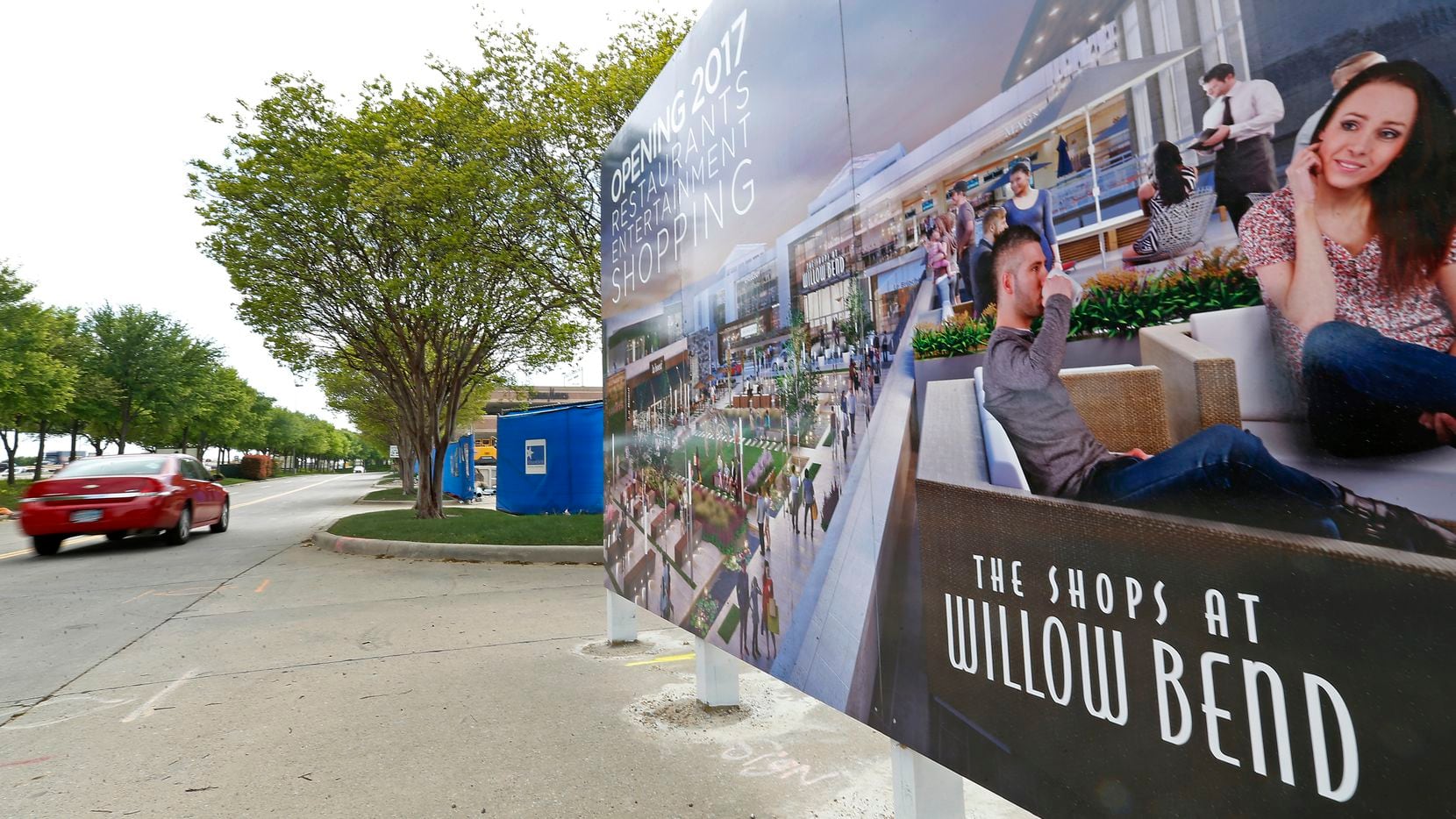 A car passes by a rendering sign at the renovation project site of The Shops at Willow Bend...