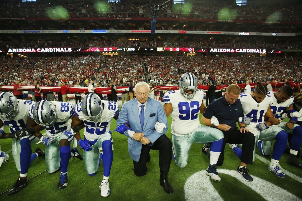 Dallas Cowboys free safety Byron Jones (31), wide receiver Noah Brown (85), defensive back Bene' Benwikere (23), owner Jerry Jones, defensive tackle Brian Price (92), head coach Jason Garrett and fullback Keith Smith (41) take a knee with teammates before the playing of the United States National Anthem before a National Football League game between the Dallas Cowboys and the Arizona Cardinals at University of Phoenix Stadium in Glendale, Arizona on Monday September 25, 2017. (Andy Jacobsohn/The Dallas Morning News)