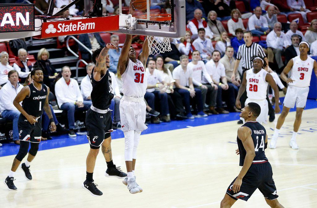 Southern Methodist Mustangs guard Jimmy Whitt (31) dunks the ball as he is pursued by...