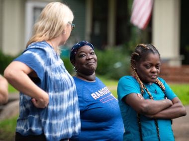 LaTasha Kelly, 39, center, reacts with a smile while speaking to friend Laquila Levy,...