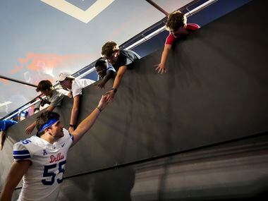 SMU defensive tackle Dylan Frazier (55) celebrates with fans as he leaves the field after a...