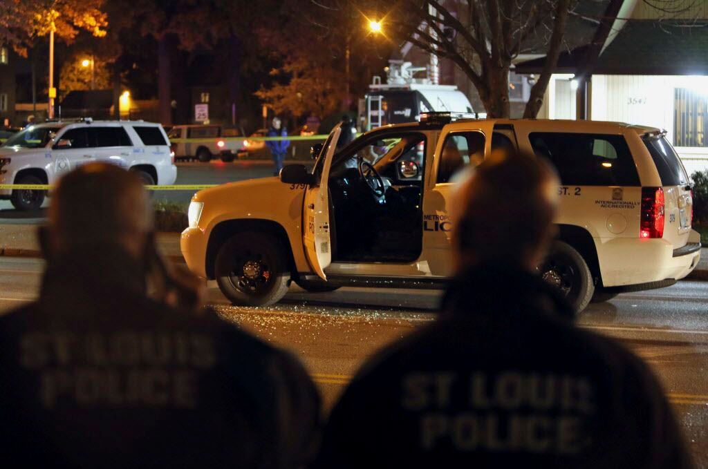 Police investigate a scene after a St. Louis police officer was shot in what the police...