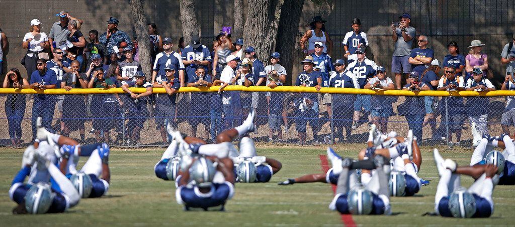 Dallas Cowboys fans watch the players during a warm-up at the training camp in Oxnard,...